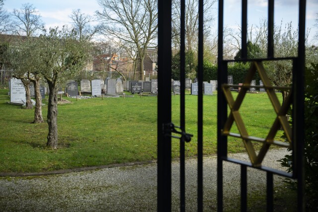 Uitzicht door het toegangshek met davidster op de historische graven van de Joodse Begraafplaats in Hilversum.